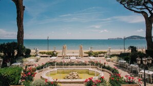 A garden with a fountain, outdoor seating, and a view of the sea. - Villa Maria Teresa Boutique Hotel (Formia)