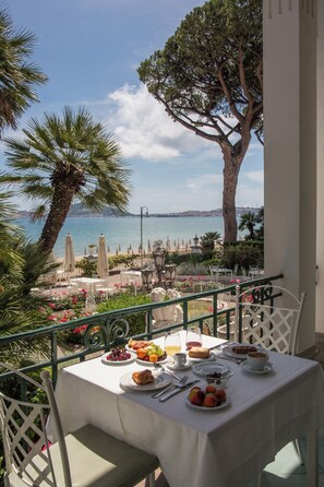 A table set with breakfast items, overlooking a coastal view with a palm tree and a large tree. - Villa Maria Teresa Boutique Hotel (Formia)