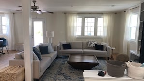 A living room with a beige sofa, a coffee table, and a patterned rug.