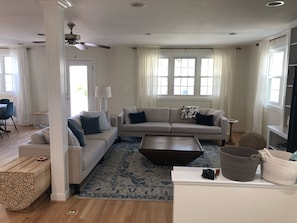 Relax in this inviting living area with a large sofa, armchair, and patterned rug.