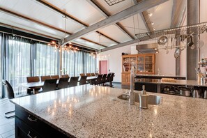 Eine moderne Küche mit Granit-Arbeitsplatten, Edelstahlgeräten und einer großen Kochinsel mit Spüle.