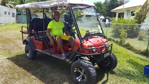 Un carrito de golf rojo con un conductor y un pasajero.