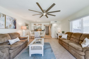 A spacious living room with two brown sofas, a white coffee table, and a ceiling fan. - Direct Ocean View- Heated Pool- New Wrap Around Balcony- (Indialantic)