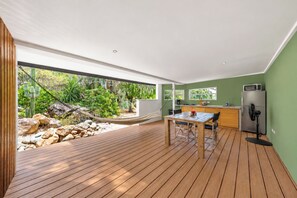 A modern kitchen with a wooden table and chairs, a refrigerator, and a microwave. - Unique experience in the nature of Aruba #2 (Paradera)