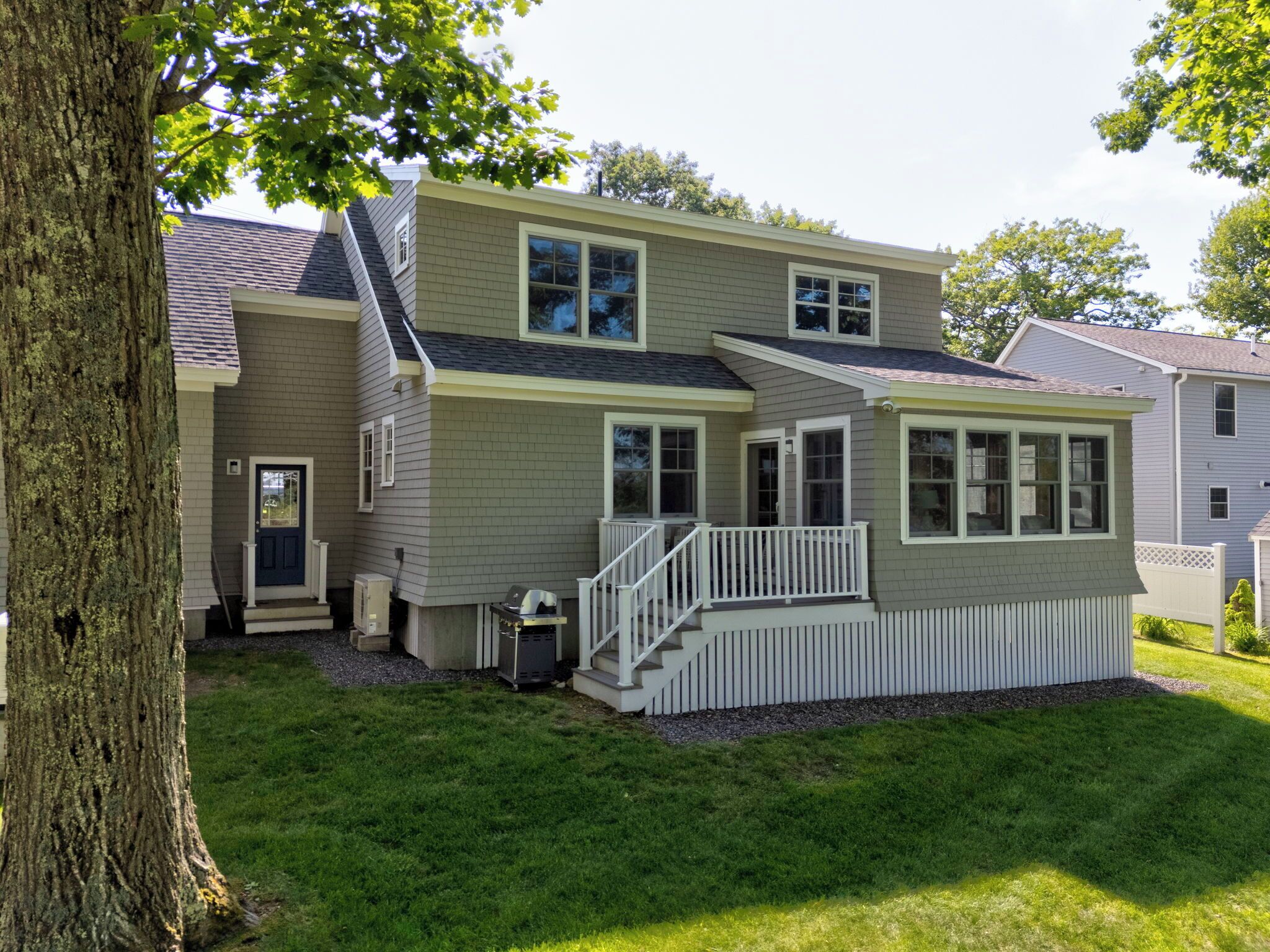 A two-story house with a front porch, a garage, and a well-maintained lawn.