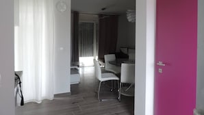 Un espace de vie moderne comprenant un coin repas, un escalier et une porte d’un rose vif.