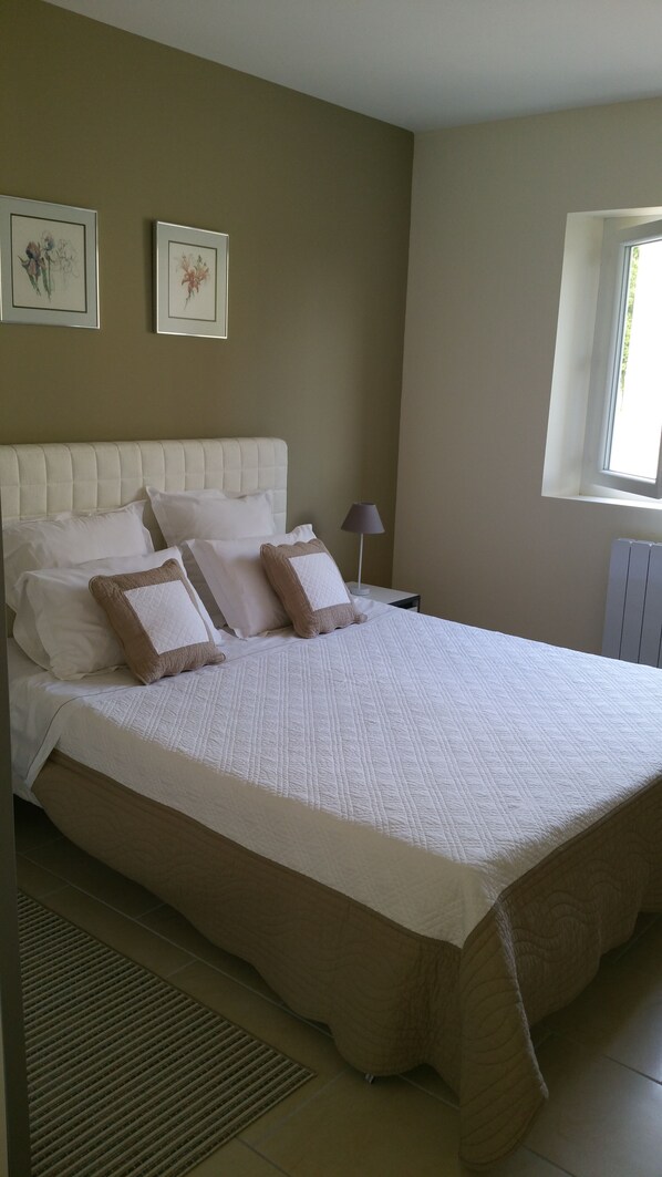 A bedroom with a large bed, headboard, and two bedside tables with lamps. - LE Calme Dans UN Ecrin DE Verdure (POUPAS)