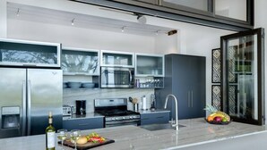 Una cucina moderna con elettrodomestici in acciaio inossidabile, un piano di lavoro in marmo e un'ampia finestra.