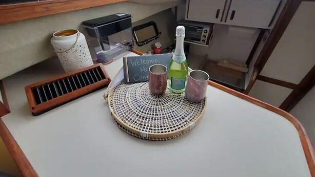 A small kitchenette area with a coffee maker, a toaster, a bottle of champagne, and a sign that reads "Welcome Mr. Cong."