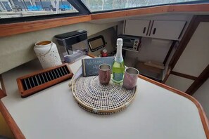A small kitchenette area with a coffee maker, a toaster, a bottle of champagne, and a sign that reads "Welcome Mr. Cong." - Irish Mist V @ Reefpoint Marina (Racine)