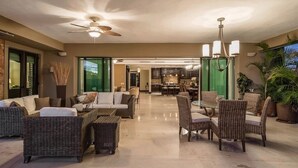 A spacious living area with wicker furniture, a ceiling fan, and a dining area with chairs and a table. - Luxury Ocean View Ground Floor, Premier Golf and Beach Clubs (Punta Mita)