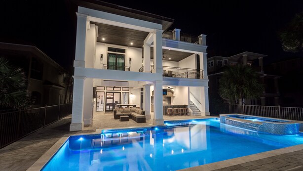 A two-story house with a swimming pool, a balcony, and a staircase leading to the upper floor. - Destin- Miramar Beach Area- Seas the Day Stunning home with ocean views (Destin)