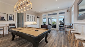 A spacious room with a pool table, a foosball table, and a billiards setup. - Destin- Miramar Beach Area- Seas the Day Stunning home with ocean views (Destin)
