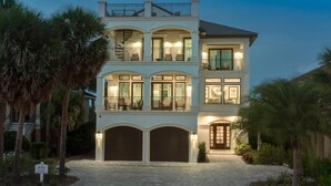 A two-story house with a balcony on the upper floor, large windows, and a driveway. - Destin- Miramar Beach Area- Seas the Day Stunning home with ocean views (Destin)