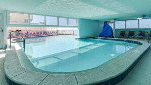 An indoor swimming pool with clear water, a tiled deck, and a sunroof. - Penthouse! Great Rates! Quiet, Clean, Well Maintained Building. Book Now. (Panama City Beach)