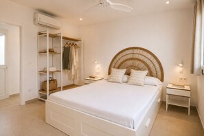 A bedroom with a bed, bedside tables, a wardrobe, and a ceiling fan.