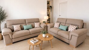 A living room with two sofas, a coffee table, a lamp, and a bookshelf.