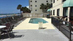 A pool area with lounge chairs and a sign indicating a 'Fool Area' with rules. - Ground floor Condo - No need for elevators - Steps away to the beach and pool. (Murrells Inlet)