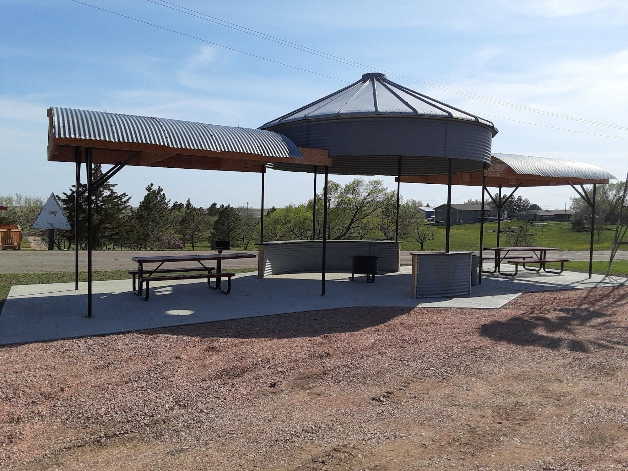 A covered picnic area with benches and a grill.
