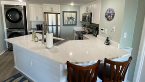 A modern kitchen with white cabinetry, stainless steel appliances, and a marble island. - Renovated Oceanfront Resort and oceanview condo - 3521 Villamare (Hilton Head Island)