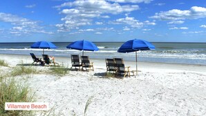 A beach with three blue umbrellas and beach chairs. - Renovated Oceanfront Resort and oceanview condo - 3521 Villamare (Hilton Head Island)