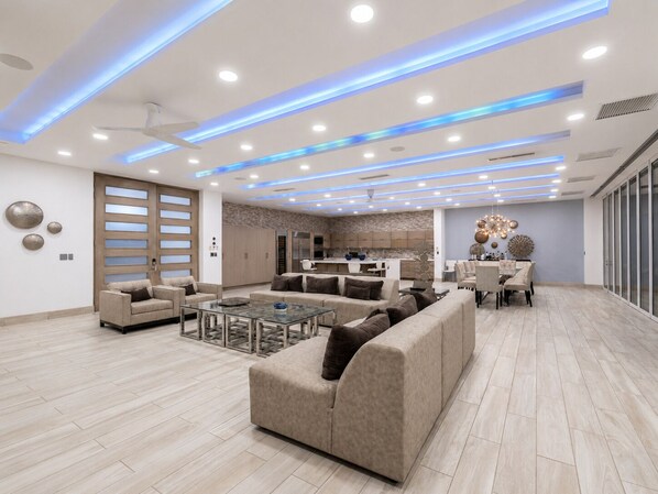 A spacious living area with a sofa, coffee table, and a dining table set for four.