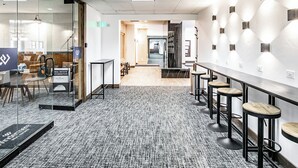 A modern office space with glass walls, a long counter with stools, and a carpeted floor. - Shadow Ridge 411 | Walk 2 Lifts | Mtn Views | Top Floor | Kitchen | Fireplace | Pool & Hot Tub (Park City)
