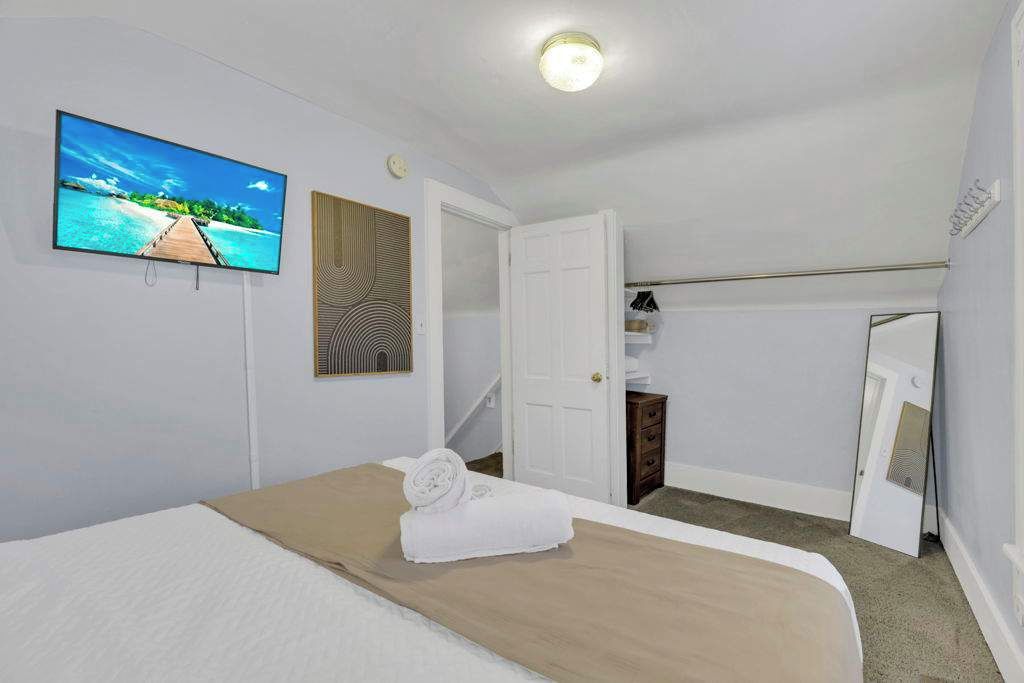 Ein Hotelzimmer mit einem Bett, einem Fernseher, einer Tür und einem kleinen Schrank.