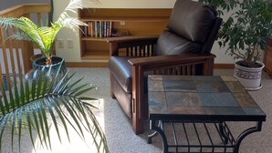 Un salon chaleureux avec un canapé en cuir, une table basse et une bibliothèque.