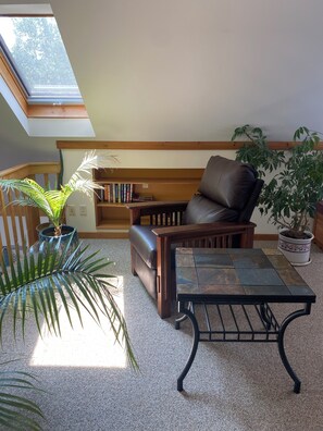 Un salon chaleureux avec un canapé en cuir, une table basse et une bibliothèque.