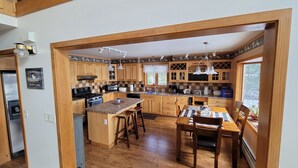 A spacious kitchen with wooden cabinets, a central island, and a dining area with a table and chairs.