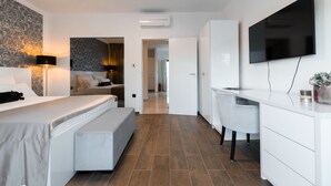 A modern hotel room with a bed, bedside table, desk, and TV. - WISH Apartments (Korcula)