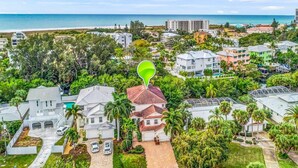 Un barrio residencial con casas, una playa y un edificio grande al fondo.