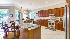 Una cocina moderna con armarios de madera, electrodomésticos de acero inoxidable y una isla grande con asientos.