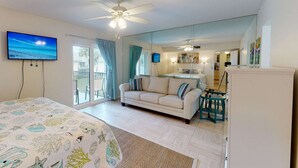A bedroom with a bed, a sofa, a desk, a ceiling fan, and a TV. - Sea Village Gulf Views 2nd Floor Condo (Siesta Key)