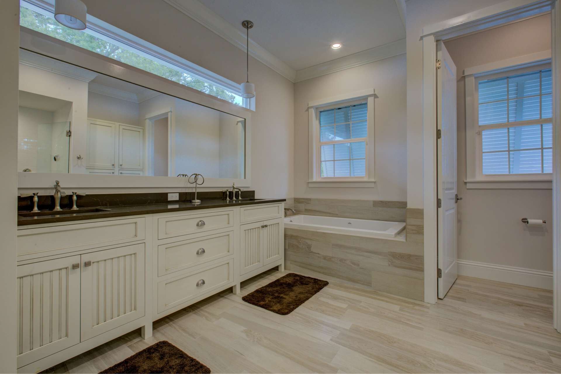 A modern bathroom with a large vanity, a bathtub, and a walk-in shower.