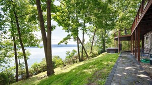 A lakeside property with a stone pathway leading to a covered outdoor area.