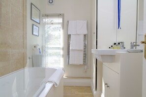 Ein Badezimmer mit Badewanne, Toilette, Waschbecken und Handtuchhalter.