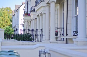 A row of classical buildings with white facades and black iron railings. - Notting Hill Bright & Welcoming with King Beds (London)