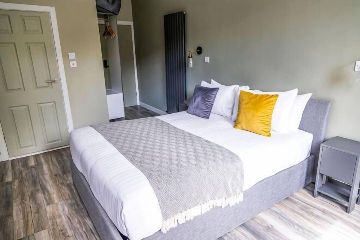 A bedroom with a bed, bedside table, and a door.