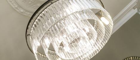 A chandelier with a circular design and a clock on the wall.