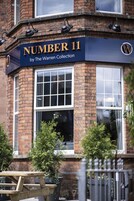 A building with a sign reading "NUMBER 11 by The Warren Collection".