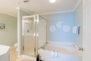 Une salle de bain avec une douche à parois de verre, une baignoire et des toilettes.