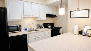 A modern kitchen with white cabinets, a black refrigerator, a microwave, a stove, and a sink. - Down Town Convenience, TRAX, Self Check-In Studio (Salt Lake City)