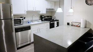 A modern kitchen with stainless steel appliances, white cabinets, and a granite countertop. - King Bed*Extensive Cleaning Protocol*Self Check-In (Salt Lake City)