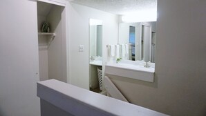 A bathroom with a white vanity, a mirror, and a towel rack. - Two Bedroom Loft, King Beds, Down Town Convenience (Salt Lake City)