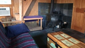 A cozy cabin interior with a wooden staircase, a fireplace, a sofa, and a chest of drawers. - Micro house cabin located near Silver Mines Recreation Area. (Fredericktown)