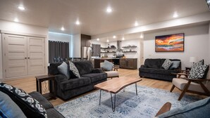 Ein modernes Wohnzimmer mit zwei Sofas, einem Couchtisch und einem Essbereich mit Stühlen.
