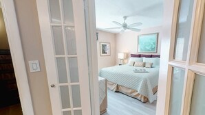 A bedroom with a bed, a ceiling fan, and a framed picture on the wall. - Bay Oaks, 4th Floor Corner - Elevator (Siesta Key)