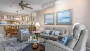 A modern living room with a sofa, armchairs, a coffee table, and a dining area with chairs and a table. - Bay Oaks, 4th Floor Corner - Elevator (Siesta Key)